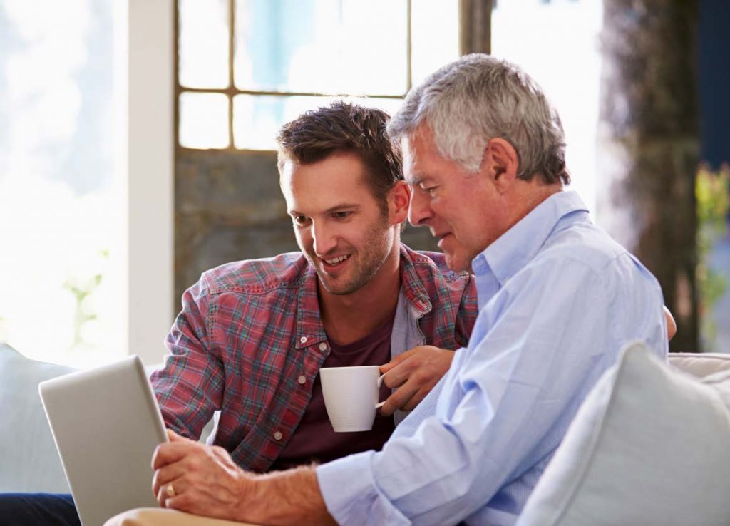 Image of older adult being assisted with technology